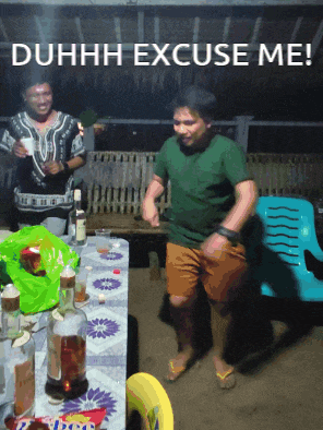a man dancing in front of a table that says duhhh excuse me on it