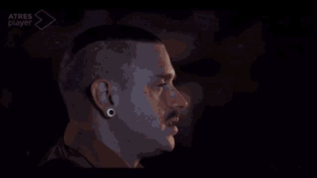 a close up of a man 's face with atres player on the bottom right