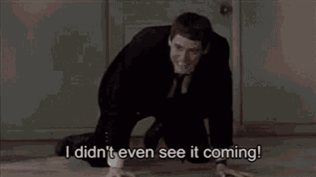 a man in a suit and tie is kneeling on the floor and saying `` i didn 't even see it coming ''