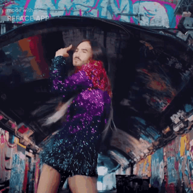 a man with long hair and a beard is dancing in front of a wall with graffiti on it and the word reface app visible