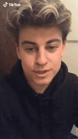 a young man wearing a black hoodie has a tiktok logo on his face