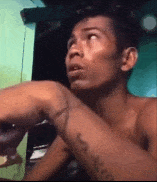 a man without a shirt has a tattoo on his arm that says jesus