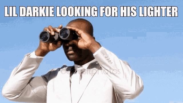 a man in a suit is looking through binoculars with the caption lil darkie looking for his lighter below him