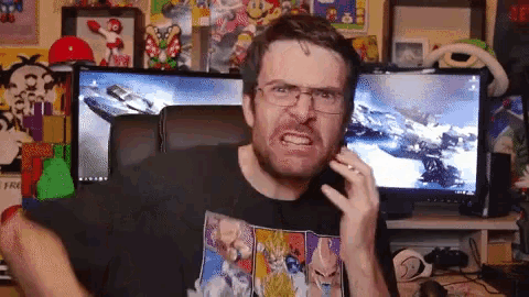 a man wearing glasses is sitting in front of a computer screen with a game on it