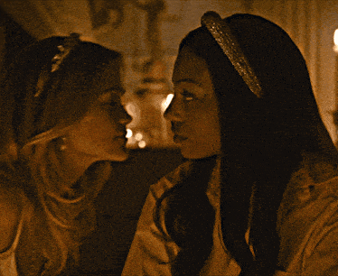 two women looking at each other with one wearing a headband with rhinestones