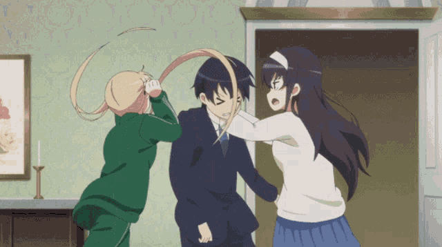 a man and two women are fighting in a room with a picture on the wall
