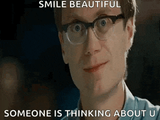 a man wearing glasses is smiling and someone is thinking about him .