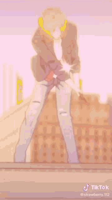a man in a purple jacket is standing on a pink surface holding a stick .