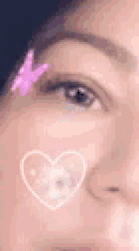 a close up of a woman 's face with a heart on it and a butterfly on her eyebrow .