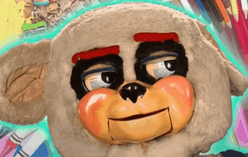 a close up of a stuffed animal 's face with colored pencils in the background