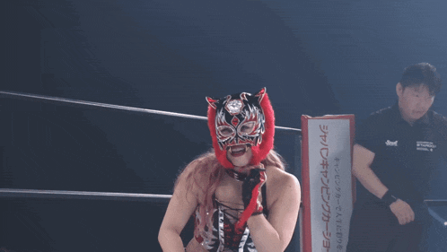 a woman in a wrestling ring holding a sign that says 2025