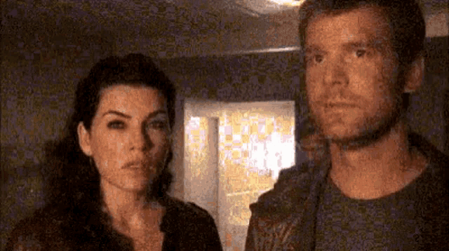 a man and a woman are standing next to each other in a room .