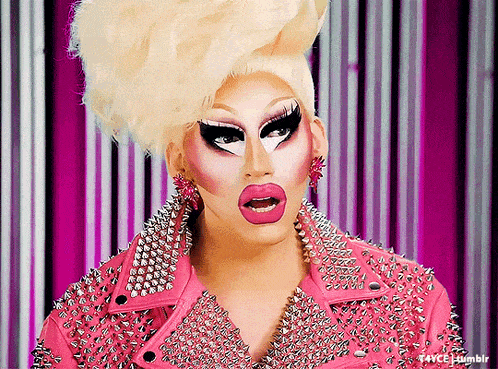 a drag queen wearing a pink jacket with spikes
