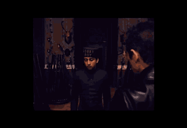 a man in a black jacket is holding a rosary in his hand