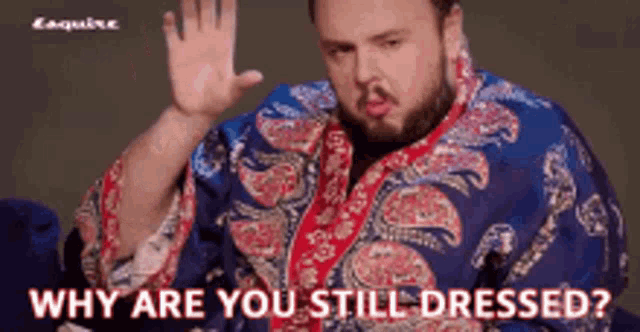 a man with a beard wearing a blue and red paisley shirt says why are you still dressed