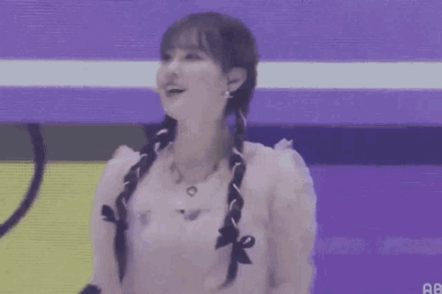 a woman is standing on a stage with her arms outstretched and smiling .
