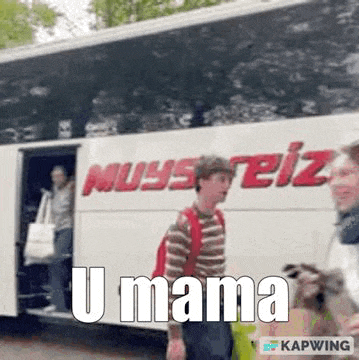 a man with a backpack is walking towards a bus with the words `` u mama '' written on it .