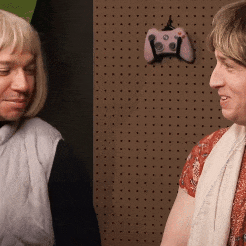 two people are standing in front of a wall with polka dots
