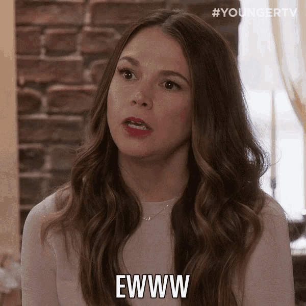 a woman with long hair says ewww in front of a brick building