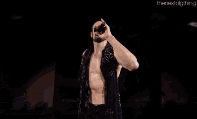 a wrestler named aiden english is singing into a microphone on a stage