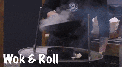 a person is stirring a pot of food and the words wok & roll are visible
