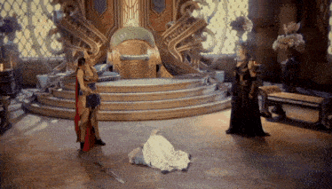 a man laying on the floor in front of a throne with a sword in his hand
