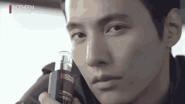 a close up of a man holding a bottle of lotion .