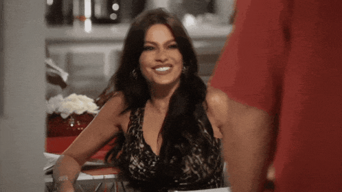 a woman in a black lace top is smiling