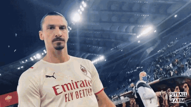 a man wearing an emirates fly better jersey