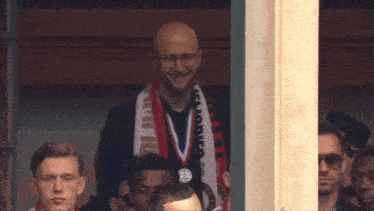 a man wearing a medal around his neck has a scarf around his neck that has the word rode on it