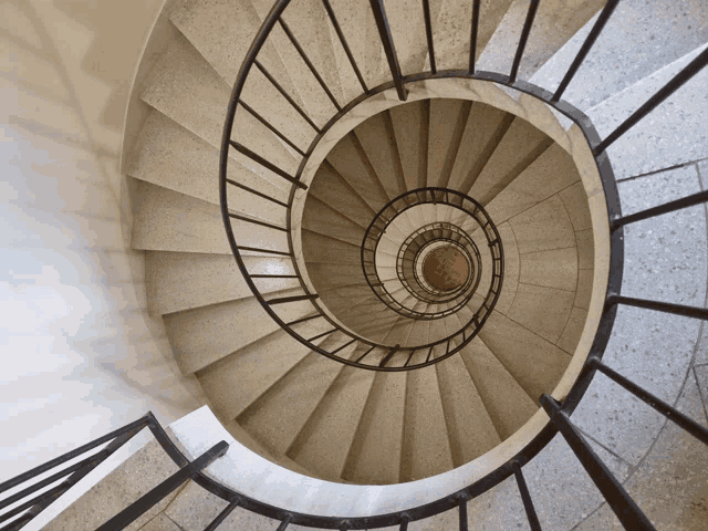 a spiral staircase with a metal railing going up