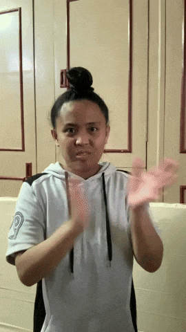 a woman wearing a white shirt with the number 9 on it is clapping her hands