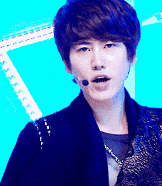 a young man with a microphone on his ear looks at the camera