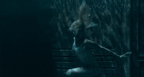 a woman is swimming in a pool with bubbles coming out of it