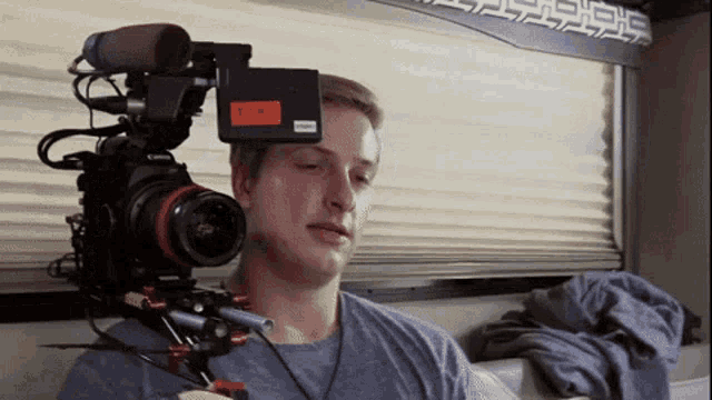 a man is holding a camera with a tag that says tia