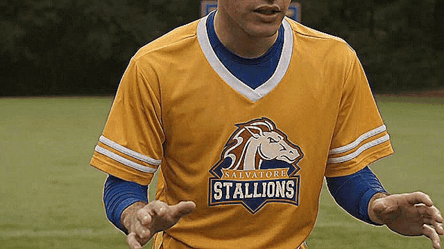 a man wearing a yellow shirt that says stallions on it