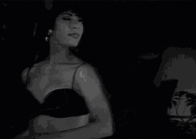a black and white photo of a woman dancing with her arms outstretched .