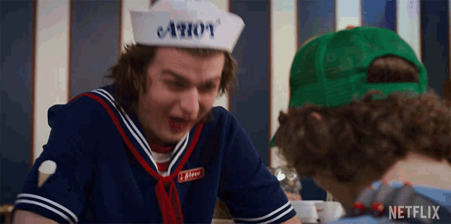 a man wearing a hat that says ahoy is talking to another man