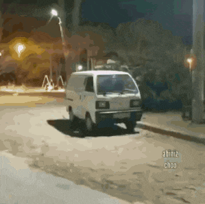 a small white van is parked on the side of the road