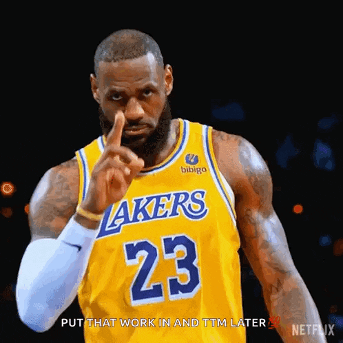lebron james is wearing a lakers jersey and pointing at something