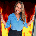 a woman in a blue shirt and black skirt is smiling in front of a fire background