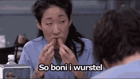 a woman is eating a hot dog with the words `` so bon i wurstel '' written on it .