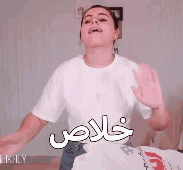 a woman wearing a white t-shirt with the word eikhly on the bottom