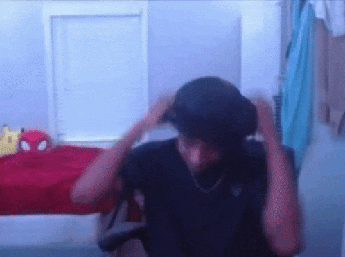 a man is sitting in a chair with his hands on his head in a room .