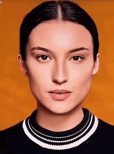 a woman wearing a black and white sweater with a striped collar