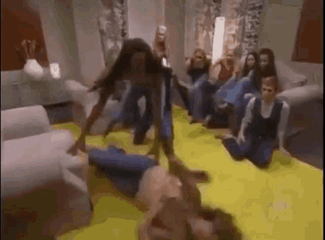 a group of people are sitting on the floor playing a game .