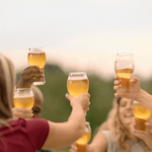 a group of people are toasting with glasses of beer that say ' amber ' on them