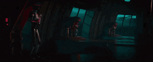 a man with a beard is holding a blue light saber in his hand in a dark room .