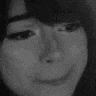 a black and white photo of a woman 's face with glasses on .