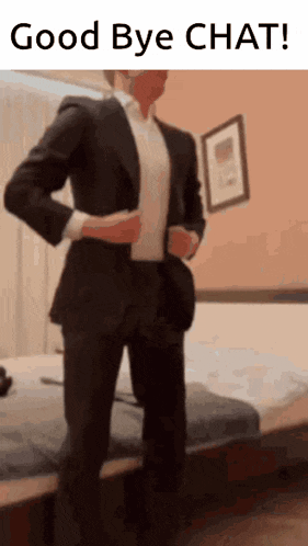 a man in a suit is standing in front of a bed with the words good bye chat written above him .